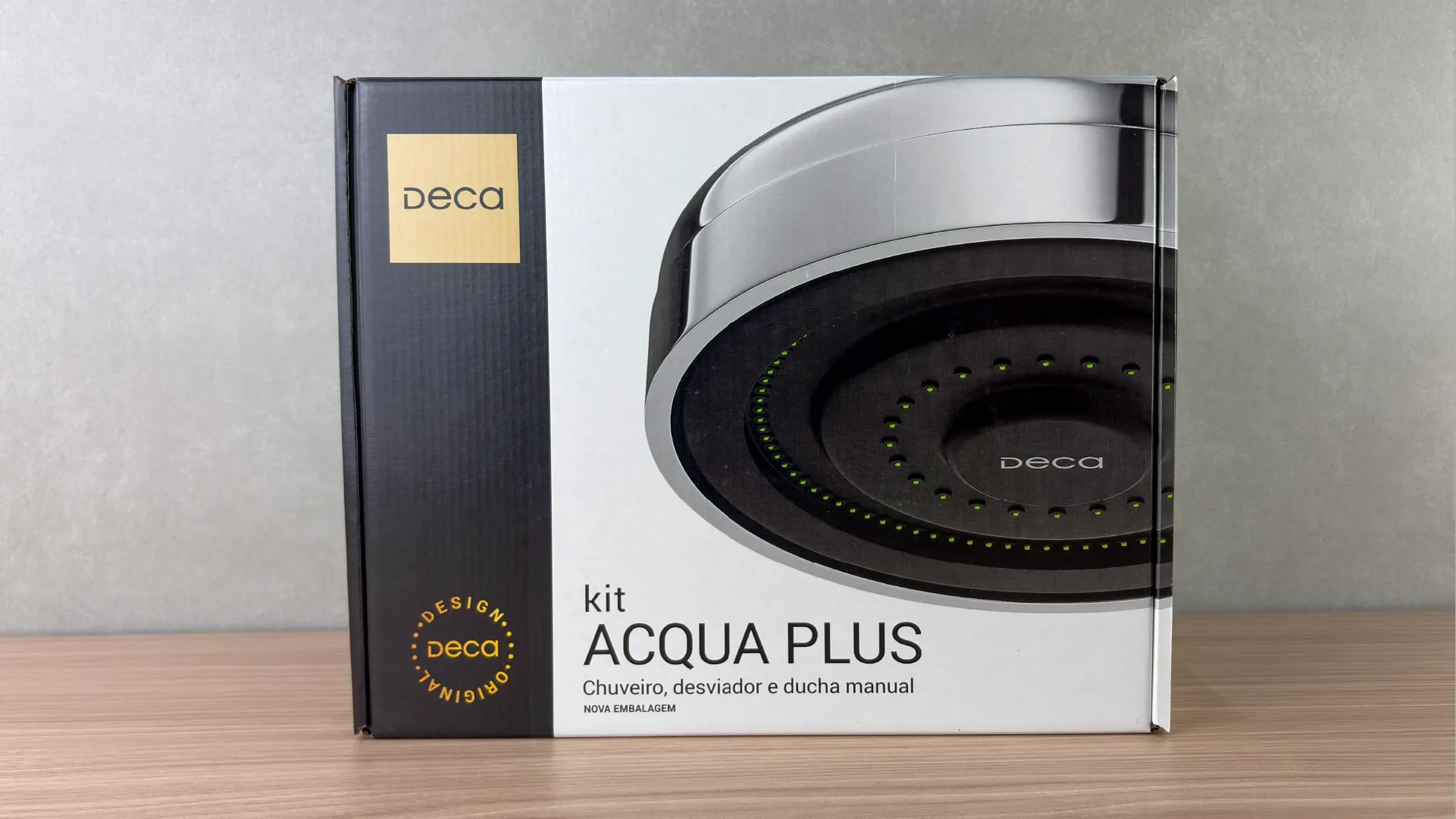 Front of the Acqua Plus kit packaging: the oversized showerhead filling the whole panel, with the Deca brand on the black side band.