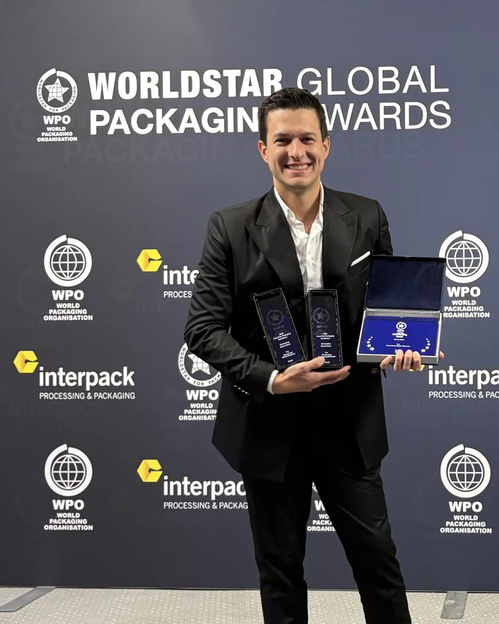 Hugo Zuffo at the WorldStar Global Packaging Awards, holding the two WorldStar trophies and the Special Award for Marketing case.